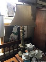 Photo of 36 inch tall metal base lamp with 15 inch square fabric shade on wooden bench display.