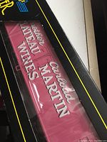 Close-up image showing red model freight car with ‘Carled Martin Chateau Wines’ lettering inside black box with yellow trim