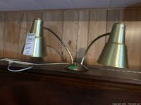 Photo of the brass dual desk lamp showing two cone-shaped adjustable lamp heads on curved arms.