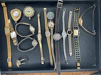Tray with all watches, ring watch and coin visible