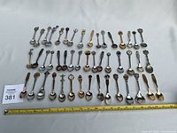 All spoons laid out in rows next to ruler for scale