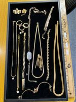 Overview of all jewellery pieces on tray beside ruler