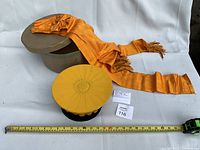 Hat with lid off, sash, ruler for scale