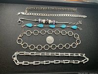 All five silver-tone jewelry pieces laid out for overview
