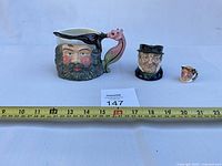 Front view of all three mugs with measuring tape