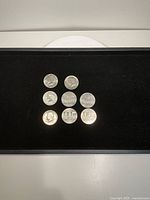 Eight coins laid out on black background