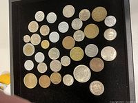 Overall view of assorted coins on black tray