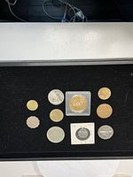 Overhead view showing all eleven coins on black background