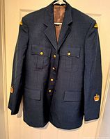 Front view of 1986 Canadian Air Force coat showing blue wool fabric, button pockets, and insignia detail on sleeves and cuffs