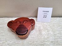 Front view of the handcrafted wooden monkey puzzle trinket box showing the monkey face and puzzle piece seams.