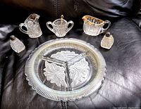 Whole set including divided relish dish, creamer, sugar bowl, salt and pepper shakers with sterling lids