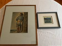 Full view of two larger framed prints on table showing Argentinian cowboy and landscape scenes