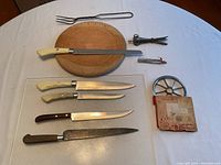 Full layout of items showing cutting board, carving knives, roasting pins, apple corer, and fork