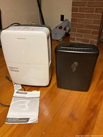 Front view of Garrison dehumidifier and Omnitech shredder with dehumidifier manual visible