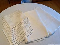 More angle of folded matching napkins placed atop the tablecloths showing fabric texture and pattern detail.