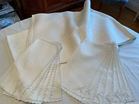 Photo of 100% linen tablecloth folded showing its size and texture with some spots visible.