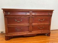 Front view of solid wood buffet showing drawer layout and brass hardware