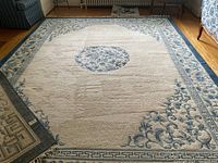 Full view of the blue and white Turco-Persian carpet showing central floral medallion and border.
