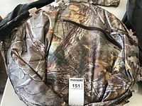 Camouflage collapsible ground blind with foldable frame shown folded.