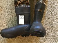 Front and side view of the pair of black rubber boots attached to camo wader pants, showing size and design.