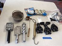 Full lot overview showing melting pot, molds, scoop, brass weight, pulleys, cables and accessories.