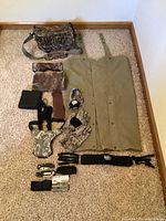 Full view of all items laid out on carpet including gaiters, bag, gloves, facemasks, multi-tool, and accessories