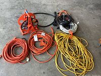 Wide view showing all cords including orange cord on reel and other color-coded coils