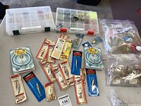 Two labeled plastic storage boxes containing assorted fishing jigs with and without plastic skirts, organized in compartments, plus several lures in original packaging and loose bobbers in plastic bags.