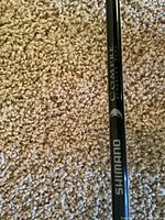 Close-up of the Shimano Compre graphite fishing rod showing branding and material type.