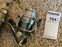 Close-up of Shimano Symetre 1500 F1 spinning reel showing model details and left-hand crank