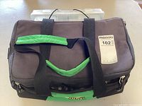 Tackle bag, grey fabric with green handles and zipper with MaxSold sticker