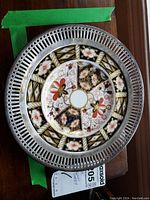 Top view of Royal Crown Derby porcelain plate showing detailed floral and geometric decoration with sterling silver lattice rim.