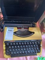 Front view of yellow Brother Charger 11 electric typewriter with black keys and label showing model and brand.