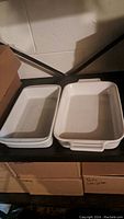Two white ceramic rectangular baking dishes side by side on a dark surface