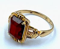 Angled front view of rectangular red carnelian gemstone and gold filigree setting