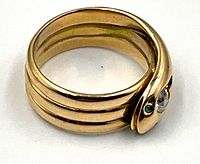 Coiled ring angled view showing band thickness and serpent head with stones.