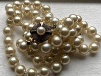 Cultured pearls draped showing decorative 10K gold clasp with central pearl