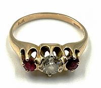 Top view of ring showing central diamond and side red gemstones