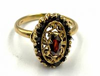 Front view of ring on white background showing top view of garnet and halo setting