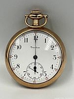 Front view of watch on neutral grey background showing dial, hands and case.