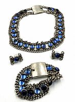 Necklace, bracelet, and earrings laid flat on white background