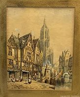 Frontal view of framed watercolor painting showing medieval street scene with cathedral