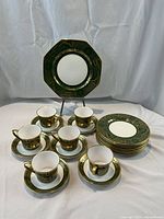 Full set arranged: one large octagonal plate on stand, stack of eight small plates, six cups with saucers.
