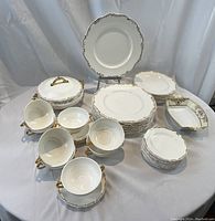 Full overview of all dinnerware pieces on white draped background