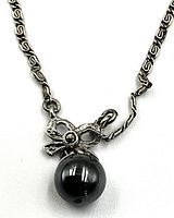 Front view of the necklace pendant showing the black-blue Tahitian pearl and bow-shaped silver setting with intricate chain links.