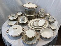 Full set arranged on white cloth backdrop showing stacks of plates, bowls, cups and serving pieces