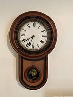 Clock hanging on wall, full front view