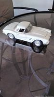 White 1962 Corvette scale model displayed on glass table.