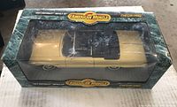 Front view of boxed 1:18 scale yellow 1964 Chevrolet Impala SS model with black roof by American Muscle, showing some age wear on box.