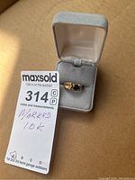 Ring displayed in open grey velvet jewelry box with auction lot tag visible